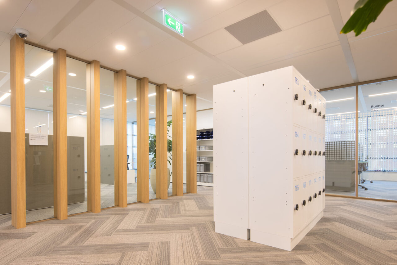 hoge glaswand tot aan systeemplafond, afgewerkt met eiken profilering