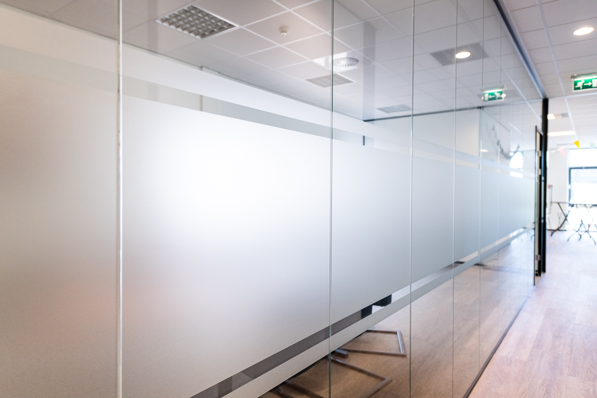 glazen scheidingswand met folie tussen hal en vergaderkamer